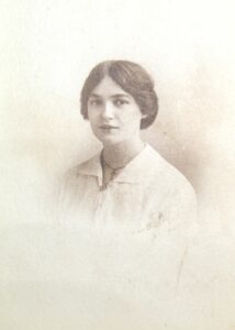 Black and white photograph of a young woman wearing a white shirt and dark hair.